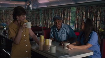 Movie still from “The Dead Don't Die” (2019), directed by Jim Jarmusch – A man sitting at a table in a diner with two women; Medium shot, Low angle