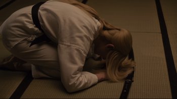 Movie still from “The Dead Don't Die” (2019), directed by Jim Jarmusch – A woman is laying on the ground with her head on the floor; Medium shot, High angle
