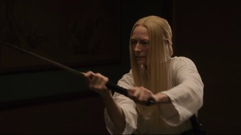 Movie still from “The Dead Don't Die” (2019), directed by Jim Jarmusch – A woman is holding a sword in her hands; Close Up shot, Over the shoulder angle