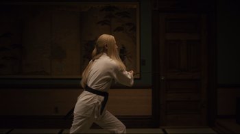 Movie still from “The Dead Don't Die” (2019), directed by Jim Jarmusch – A person with long blonde hair wearing a black belt; Medium shot, Over the shoulder angle