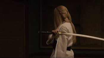 Movie still from “The Dead Don't Die” (2019), directed by Jim Jarmusch – A woman holding a sword while wearing a white robe; Medium shot, Over the shoulder angle