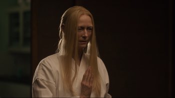 Movie still from “The Dead Don't Die” (2019), directed by Jim Jarmusch – A woman with long blonde hair wearing a white robe; Close Up shot, High angle