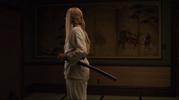 Movie still from “The Dead Don't Die” (2019), directed by Jim Jarmusch – A person holding a sword in their hands; Medium shot, Over the shoulder angle