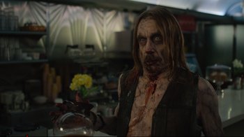 Movie still from “The Dead Don't Die” (2019), directed by Jim Jarmusch – A man with a bloody face holding a bowl of food; Close Up shot, Over the shoulder angle