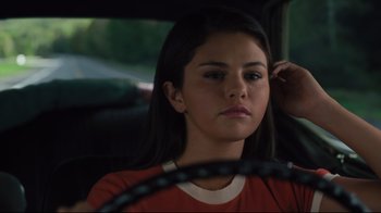 Movie still from “The Dead Don't Die” (2019), directed by Jim Jarmusch – A young woman sitting in the back seat of a car; Close Up shot, Over the shoulder angle