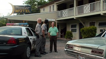 Movie still from “The Dead Don't Die” (2019), directed by Jim Jarmusch – A couple of men standing next to a police car; Wide shot, Low angle