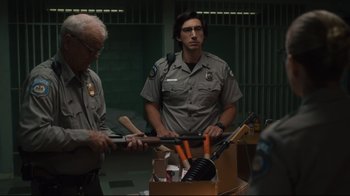 Movie still from “The Dead Don't Die” (2019), directed by Jim Jarmusch – A man in a police uniform standing next to another man in a jail cell; Medium shot, Low angle