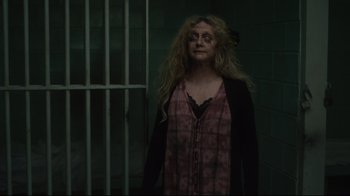 Movie still from “The Dead Don't Die” (2019), directed by Jim Jarmusch – A woman standing in front of a metal gate; Close Up shot, Low angle