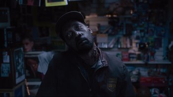 Movie still from “The Dead Don't Die” (2019), directed by Jim Jarmusch – A man with a beard and a hat in a store; Close Up shot, High angle