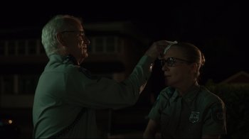 Movie still from “The Dead Don't Die” (2019), directed by Jim Jarmusch – An older man and a younger woman are in the dark; Close Up shot, Over the shoulder angle
