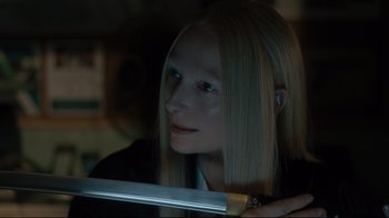 Movie still from “The Dead Don't Die” (2019), directed by Jim Jarmusch – A woman with long blonde hair holding a sword; Close Up shot, Over the shoulder angle