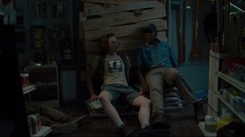 Movie still from “The Dead Don't Die” (2019), directed by Jim Jarmusch – Two people sitting on a bench in a room; Medium shot, Low angle