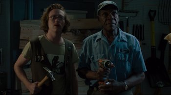 Movie still from “The Dead Don't Die” (2019), directed by Jim Jarmusch – A man and a woman standing next to each other holding tools; Medium shot, Low angle