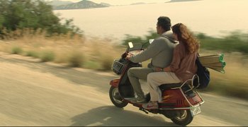 Movie still from “Climates” (2006), directed by Nuri Bilge Ceylan – A man and a woman riding a scooter down a road; Wide shot, High angle