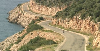 Movie still from “Climates” (2006), directed by Nuri Bilge Ceylan – A person riding a motorcycle down a curvy mountain road; Extreme Wide shot, High angle