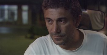 Movie still from “Climates” (2006), directed by Nuri Bilge Ceylan – A person wearing a white t - shirt; Close Up shot, Over the shoulder angle