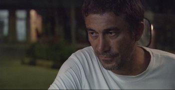 Movie still from “Climates” (2006), directed by Nuri Bilge Ceylan – A person wearing a white t - shirt; Close Up shot, Over the shoulder angle