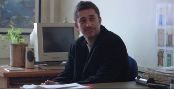 Movie still from “Climates” (2006), directed by Nuri Bilge Ceylan – A man sitting at a table in front of a computer; Close Up shot, Over the shoulder angle