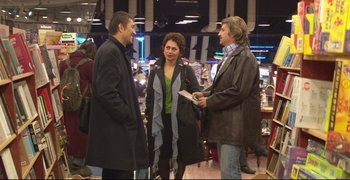 Movie still from “Climates” (2006), directed by Nuri Bilge Ceylan – A group of people standing next to each other in a room; Wide shot, Over the shoulder angle
