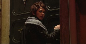 Movie still from “Climates” (2006), directed by Nuri Bilge Ceylan – A woman standing next to a wooden wall; Medium shot, Low angle