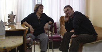 Movie still from “Climates” (2006), directed by Nuri Bilge Ceylan – A man and a woman sitting in a living room next to each other; Medium shot, High angle