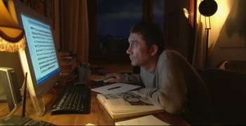 Movie still from “Climates” (2006), directed by Nuri Bilge Ceylan – A man sitting in front of a computer at a desk; Medium shot, High angle
