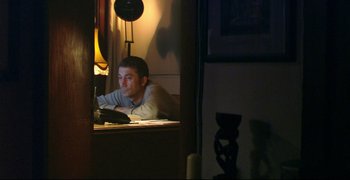 Movie still from “Climates” (2006), directed by Nuri Bilge Ceylan – A man sitting in front of a computer at night; Medium shot, High angle