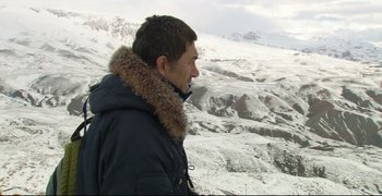 Movie still from “Climates” (2006), directed by Nuri Bilge Ceylan – A young man standing on top of a snow covered slope; Wide shot, Over the shoulder angle