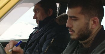 Movie still from “Climates” (2006), directed by Nuri Bilge Ceylan – Two men sitting side by side in the back of a car; Close Up shot, Over the shoulder angle