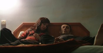 Movie still from “Climates” (2006), directed by Nuri Bilge Ceylan – A man and a woman sitting on a couch; Medium shot, Overhead angle