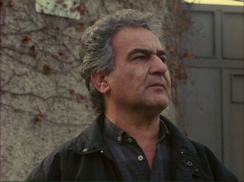 Movie still from “Close-Up” (1990), directed by Abbas Kiarostami – An older man with grey hair looking up at the sky; Close Up shot, Low angle