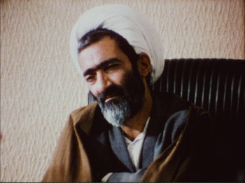 Movie still from “Close-Up” (1990), directed by Abbas Kiarostami – An older man with a beard wearing a white turban; Close Up shot, High angle