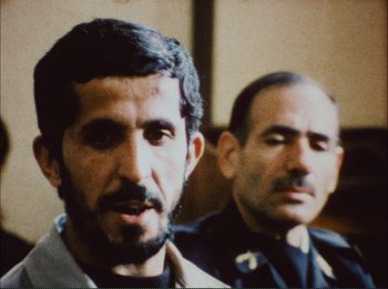 Movie still from “Close-Up” (1990), directed by Abbas Kiarostami – Two men are standing next to each other; Close Up shot, Over the shoulder angle