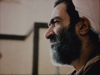Movie still from “Close-Up” (1990), directed by Abbas Kiarostami – A man with a long beard and a white hat; Close Up shot, Over the shoulder angle