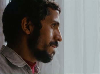 Movie still from “Close-Up” (1990), directed by Abbas Kiarostami – A person with a beard; Close Up shot, Low angle