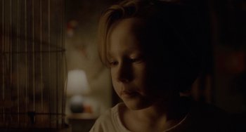 Movie still from “Closet Monster” (2015), directed by Stephen Dunn – A little girl is looking at the camera with her eyes wide open; Close Up shot, Low angle