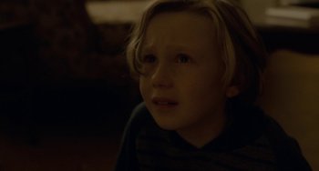Movie still from “Closet Monster” (2015), directed by Stephen Dunn – A young boy with blonde hair is looking at the camera; Close Up shot, High angle
