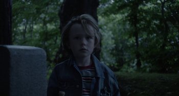 Movie still from “Closet Monster” (2015), directed by Stephen Dunn – A young boy standing in the woods at night; Close Up shot, Low angle