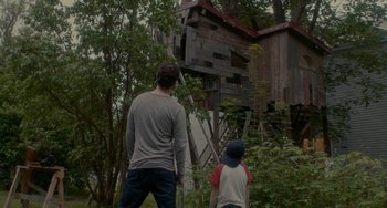 Movie still from “Closet Monster” (2015), directed by Stephen Dunn – A man and a boy standing in front of an abandoned house; Wide shot, Low angle