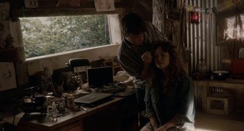 Movie still from “Closet Monster” (2015), directed by Stephen Dunn – A woman getting her hair done by a man in front of a computer; Medium shot, Over the shoulder angle