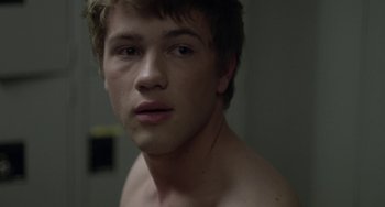 Movie still from “Closet Monster” (2015), directed by Stephen Dunn – A young man is looking into the camera; Close Up shot, Over the shoulder angle
