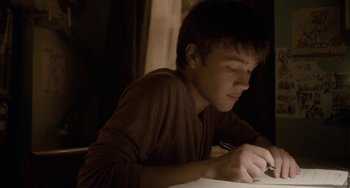 Movie still from “Closet Monster” (2015), directed by Stephen Dunn – A young man writing on a piece of paper; Close Up shot, Over the shoulder angle