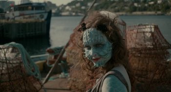 Movie still from “Closet Monster” (2015), directed by Stephen Dunn – A woman with blue makeup on her face; Close Up shot, Over the shoulder angle