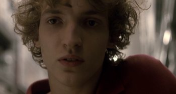 Movie still from “Closet Monster” (2015), directed by Stephen Dunn – A person with curly hair; Close Up shot, Low angle