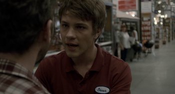 Movie still from “Closet Monster” (2015), directed by Stephen Dunn – A man in a red shirt talking to someone; Close Up shot, Over the shoulder angle