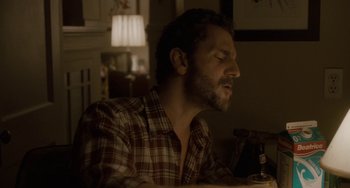 Movie still from “Closet Monster” (2015), directed by Stephen Dunn – A person sitting at a table with his eyes closed; Close Up shot, Low angle