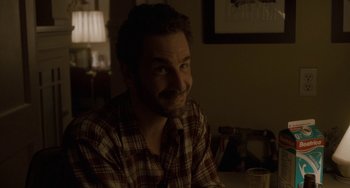 Movie still from “Closet Monster” (2015), directed by Stephen Dunn – A man sitting at a table in the dark; Close Up shot, Over the shoulder angle