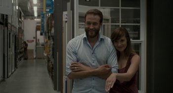 Movie still from “Closet Monster” (2015), directed by Stephen Dunn – A man and a woman standing next to each other in a store; Medium shot, Over the shoulder angle