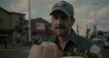 Movie still from “Closet Monster” (2015), directed by Stephen Dunn – A man holding a paper bag of food in his hands; Close Up shot, Over the shoulder angle