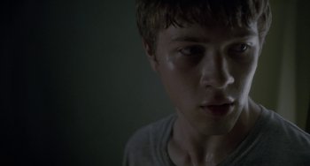 Movie still from “Closet Monster” (2015), directed by Stephen Dunn – A young man is looking into the camera; Close Up shot, Low angle